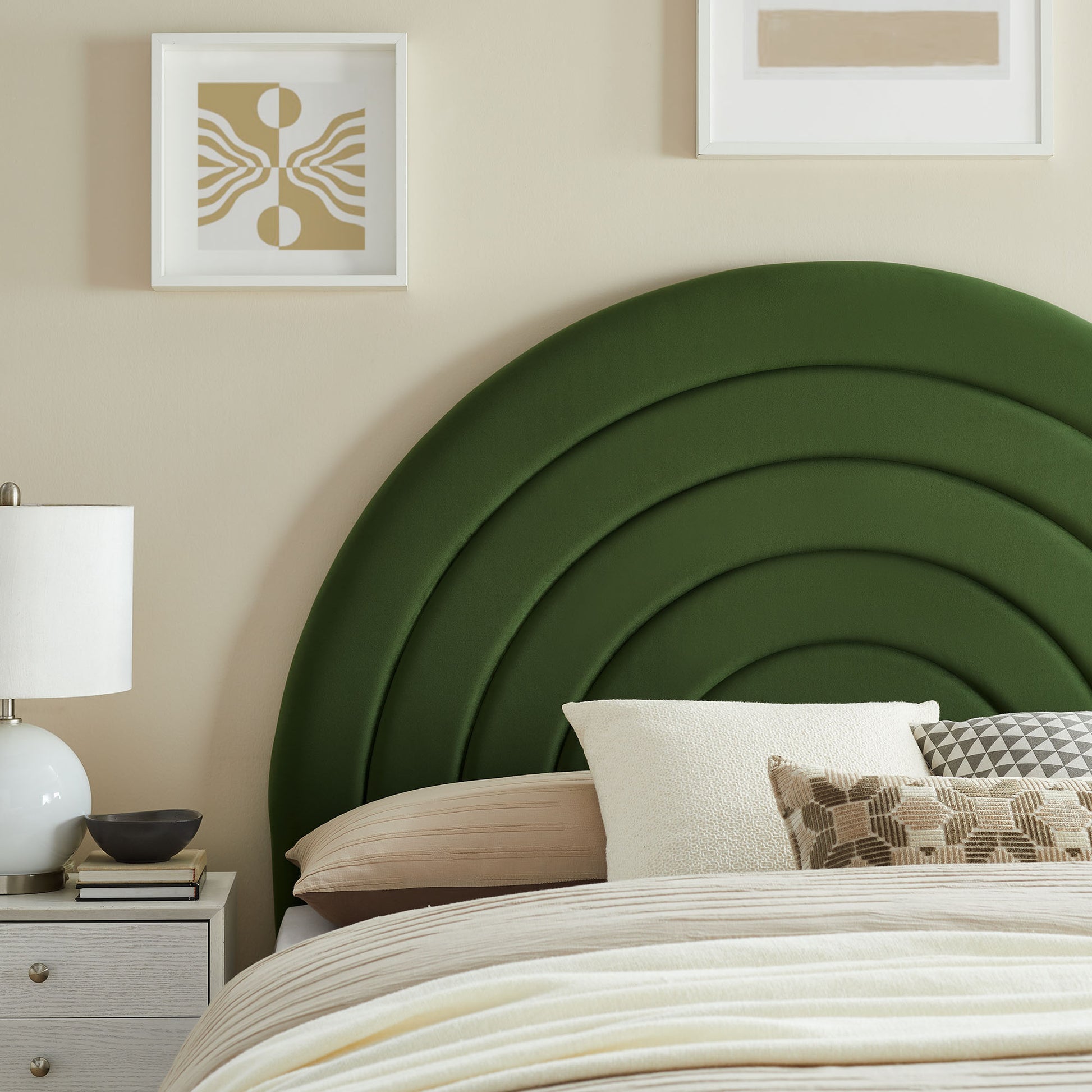 Emerald green upholstered multi-arch headboard with concentric curves, beige bedding and white pillows in a modern bedroom.