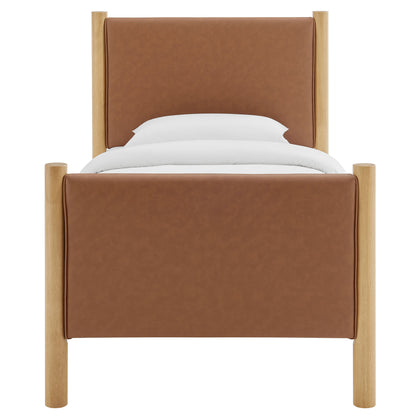 Tan faux-leather upholstered twin bed with light oak posts and white pillows.