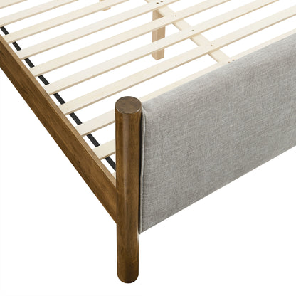 Walnut-finished wooden bed frame with slatted base and gray upholstered end panel.