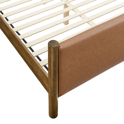 Walnut bed frame with tan vegan leather upholstered footboard panel and wooden slat base.