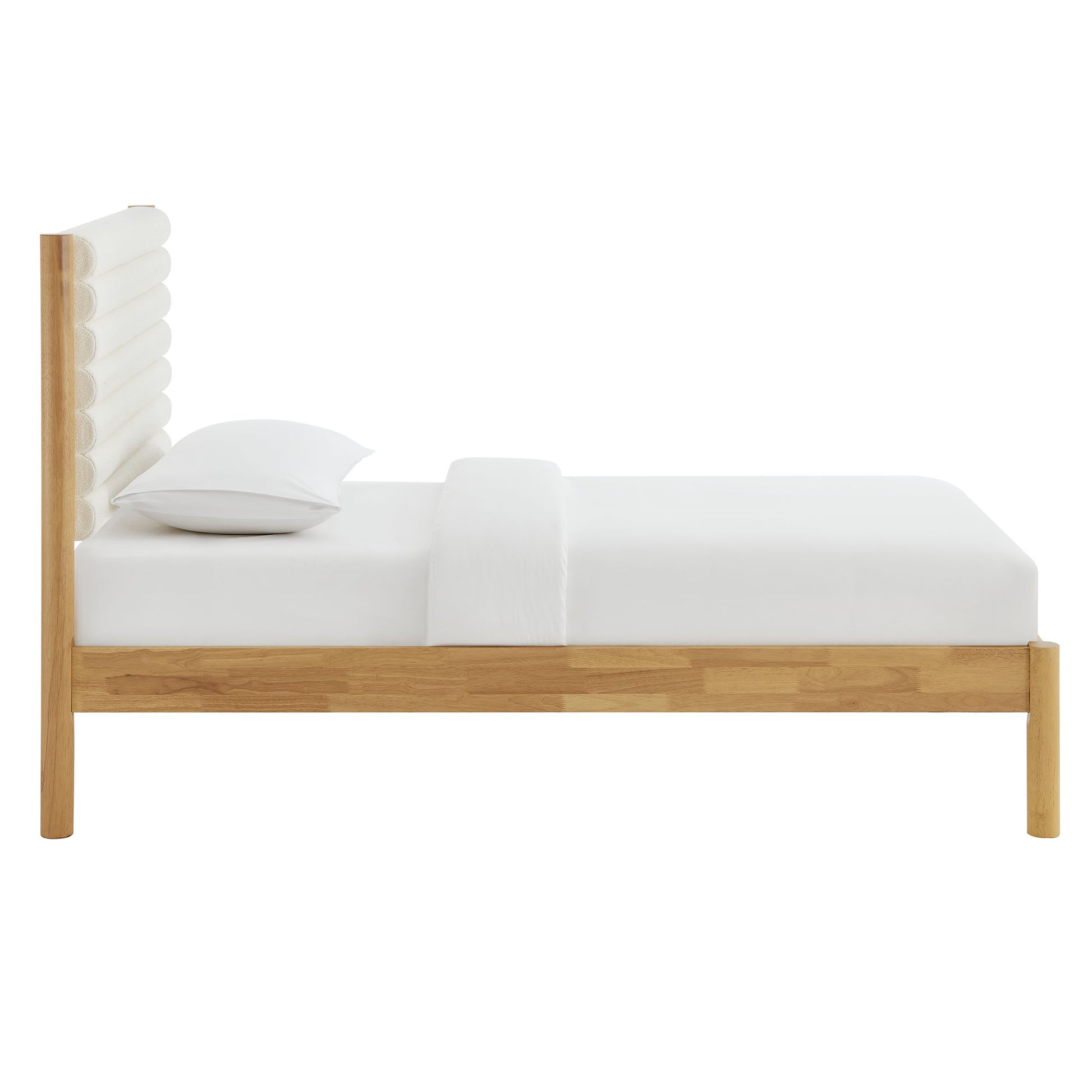 Oak platform bed with light oak frame, white upholstered headboard cushions and crisp white bedding.