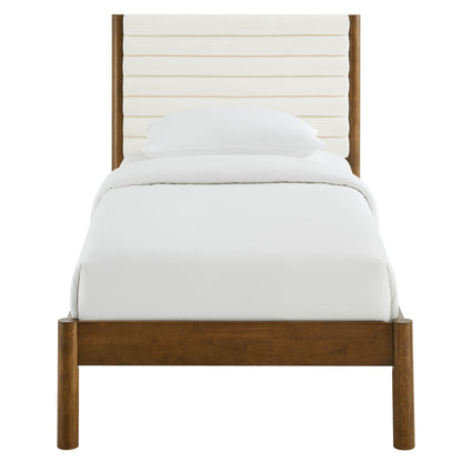 Walnut solid wood twin platform bed with a channel-tufted boucle upholstered headboard and white linens.