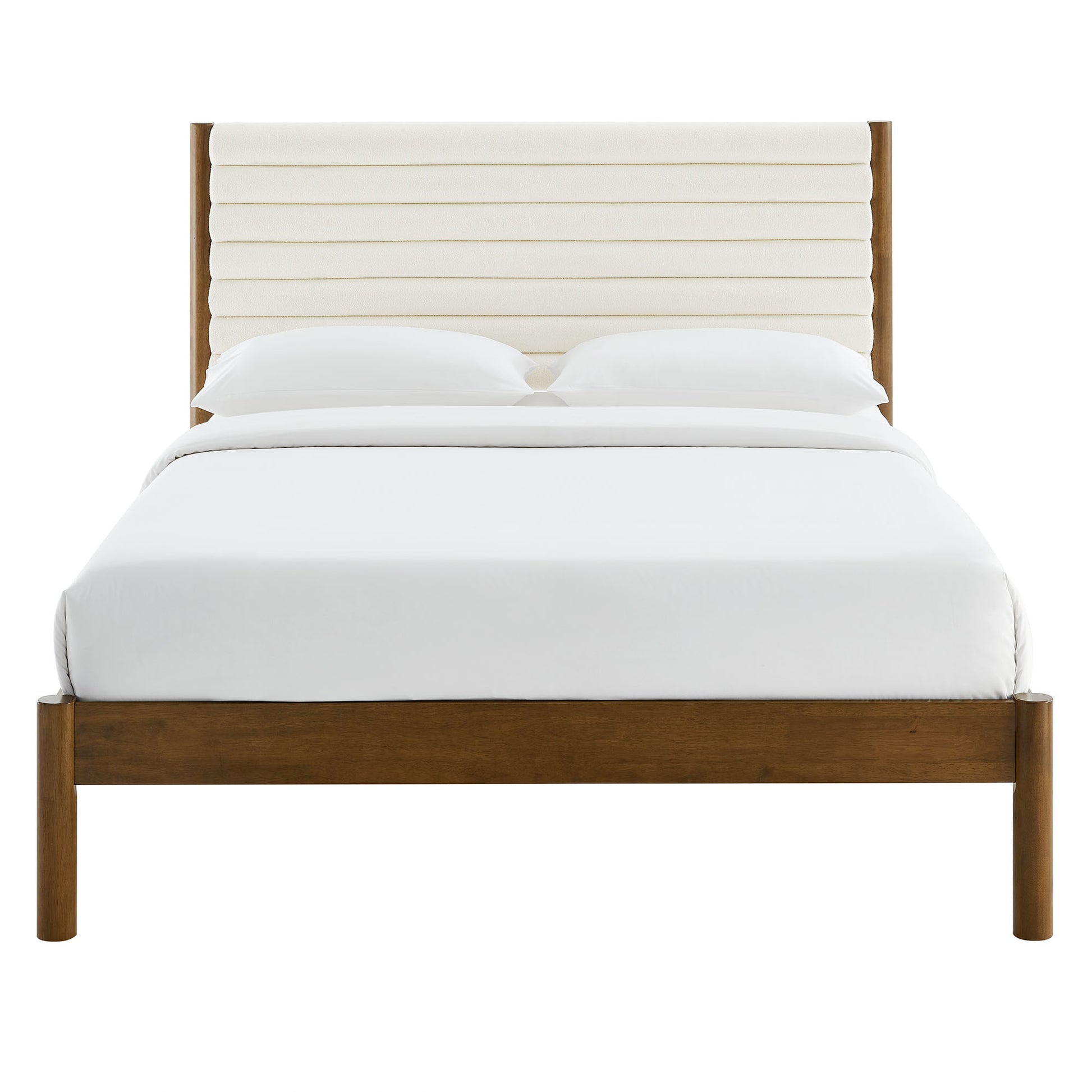 Walnut wooden platform bed with a cream channel-tufted boucle headboard and white bedding.
