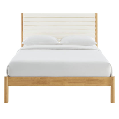 Oak-finish platform bed with padded cream headboard and white bedding.