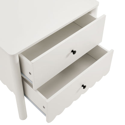 White wooden three-drawer nightstand with black knobs and a scalloped bottom drawer.