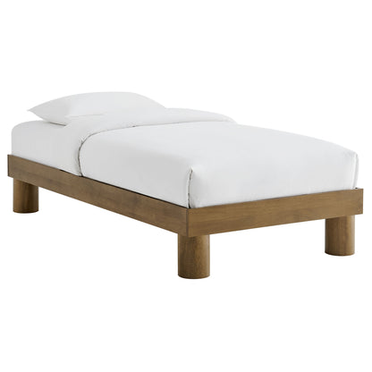 Low-profile brown-finish wooden platform bed with white duvet and pillows; minimalist Scandinavian style.