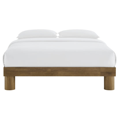 Brown wood full platform bed with a low-profile frame, white bedding and two pillows.