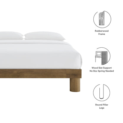 Brown natural rubberwood platform bed with white bedding, rounded pillar legs and slat support.