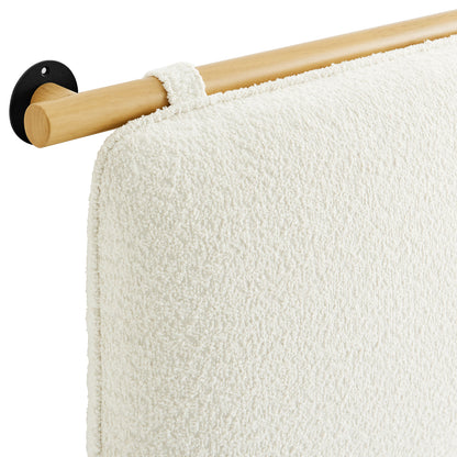 Cream textured towel on natural wood towel bar with black circular wall mount.