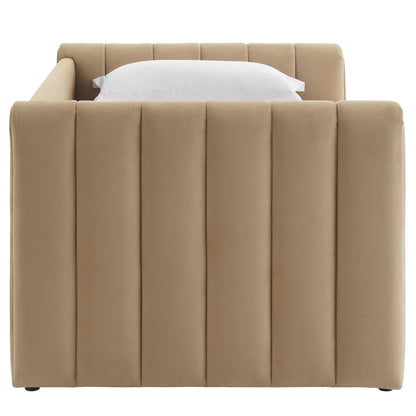 Taupe upholstered twin daybed with trundle, featuring tall vertical channel-tufted panels and a white pillow on a mattress.