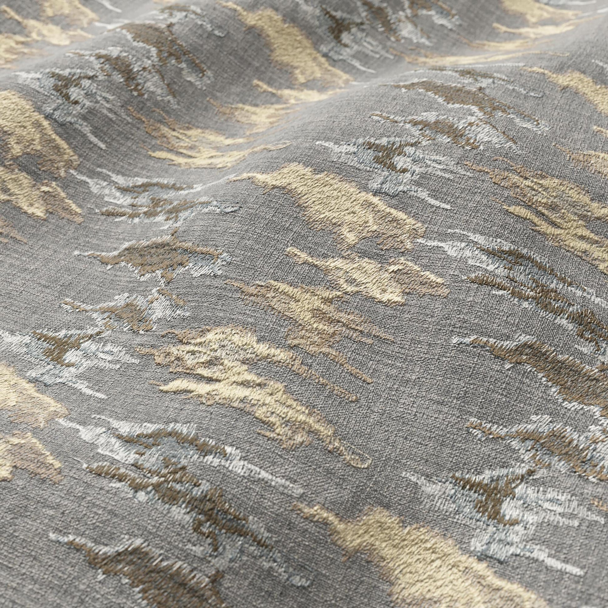 Gray fabric with abstract ikat pattern in beige, ivory and taupe; textured surface.