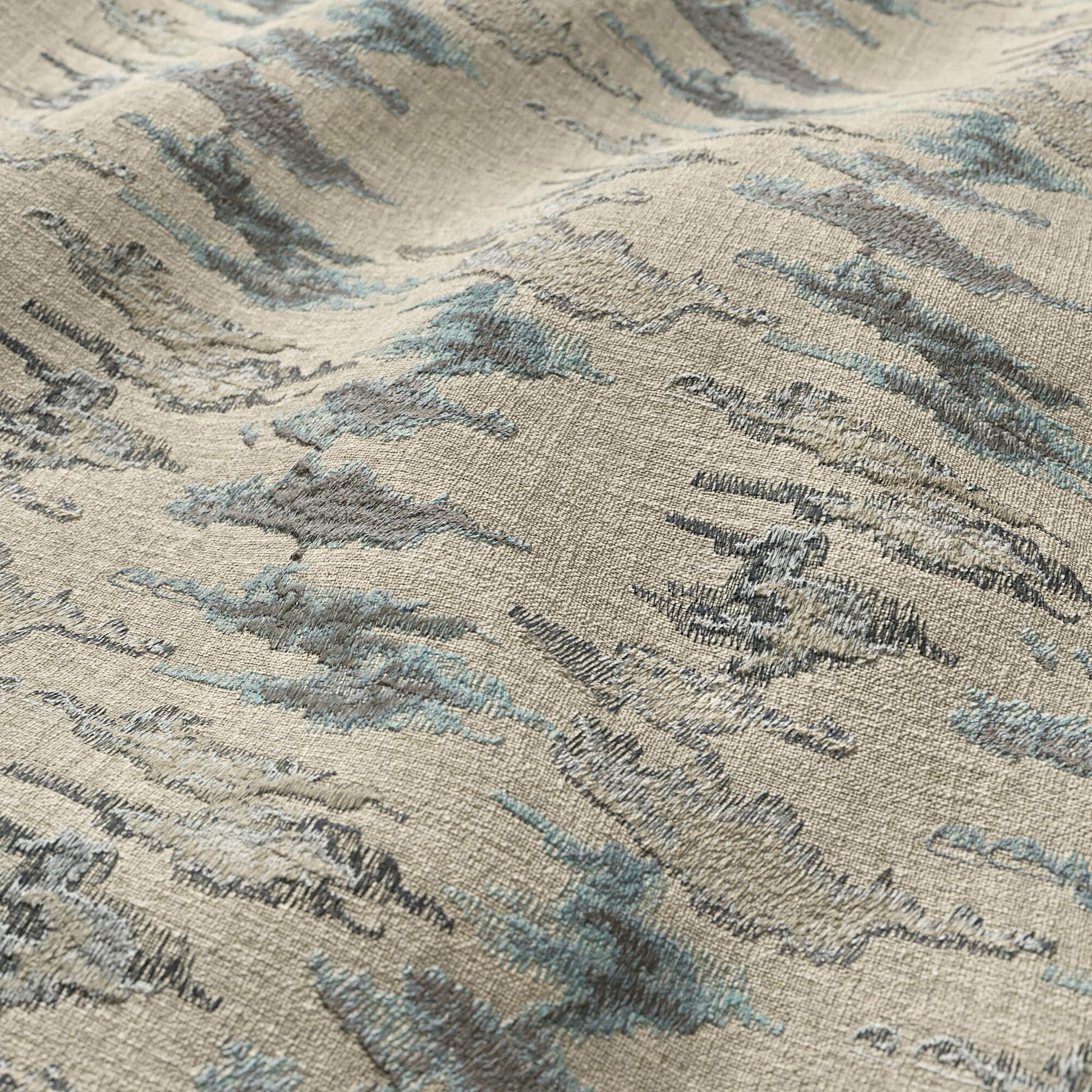 Beige woven fabric with abstract blue-gray Ikat pattern; modern, textured, suitable for upholstery and home decor.