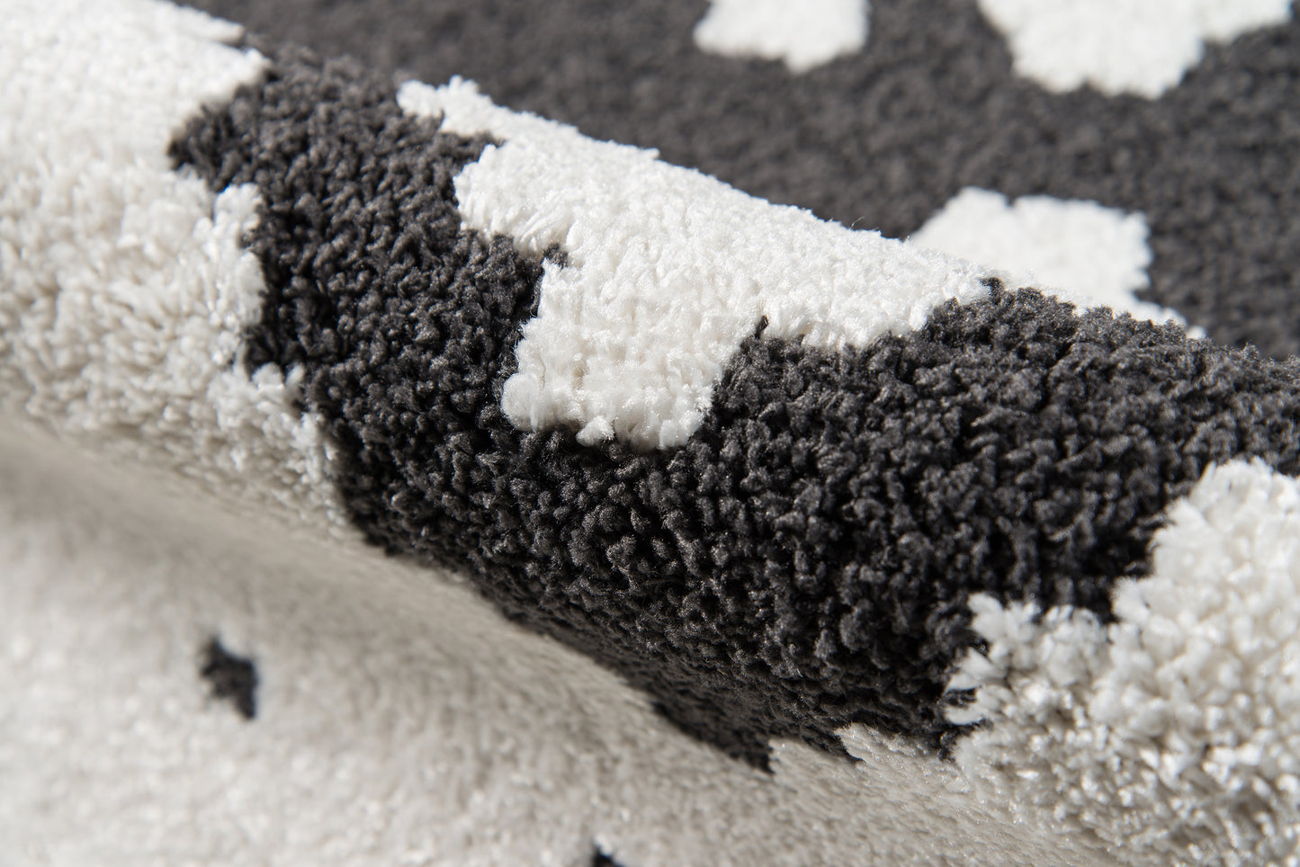 Shaggy black and ivory geometric area rug with plush high pile.