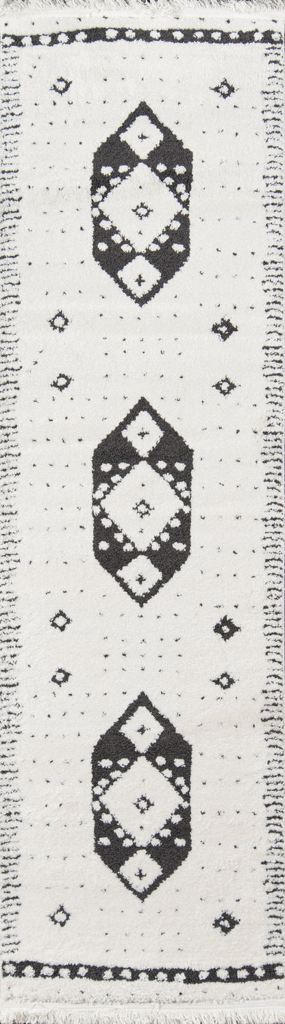 Cream rug with black diamond medallions, small dot accents, fringed ends, geometric tribal-inspired pattern.