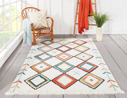 Multicolor diamond-pattern rug with fringe edges in a sunlit nook beside a wicker chair, blue throw, orange ladder.