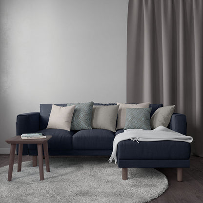 Dark navy solid textured fabric upholstery on a sectional with beige and teal pillows and a light gray throw in a modern living room.