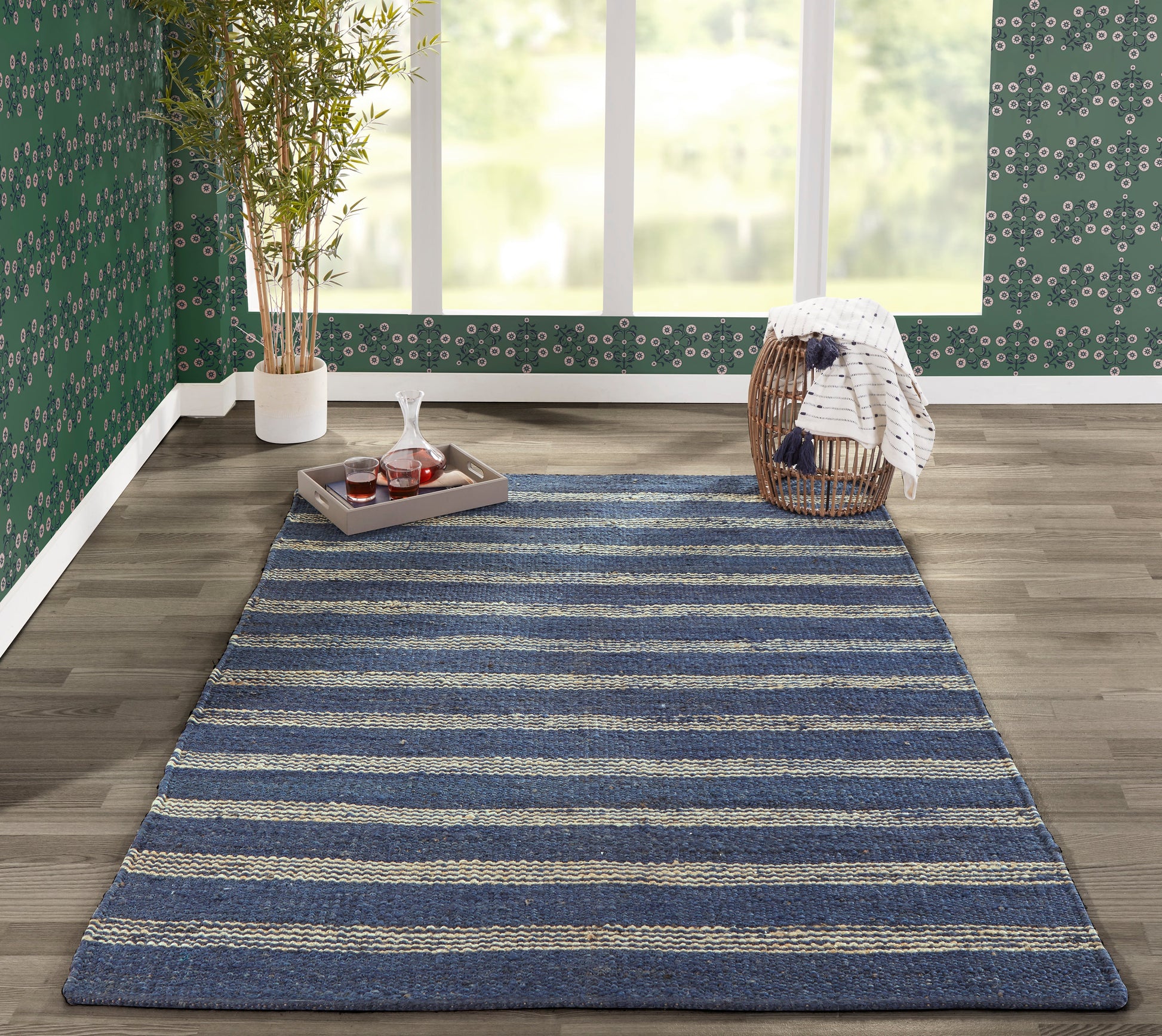 Textured woven navy blue rug with beige stripes, rectangular on a wood floor in a cozy living area.