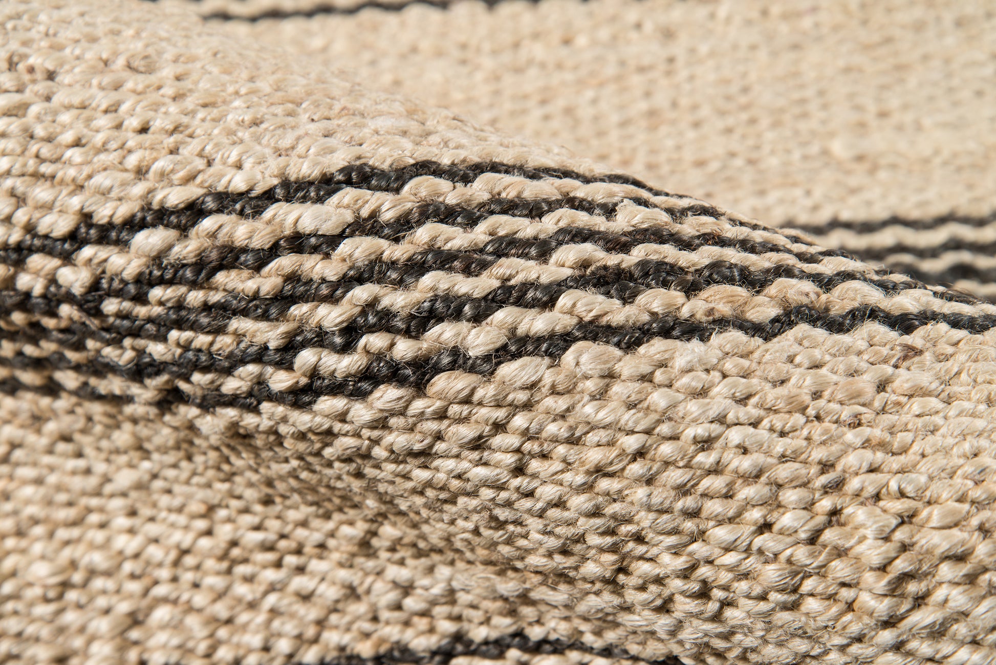 Beige woven jute runner with a black stripe pattern and textured braided weave for a rustic coastal look, 2' x 10'.