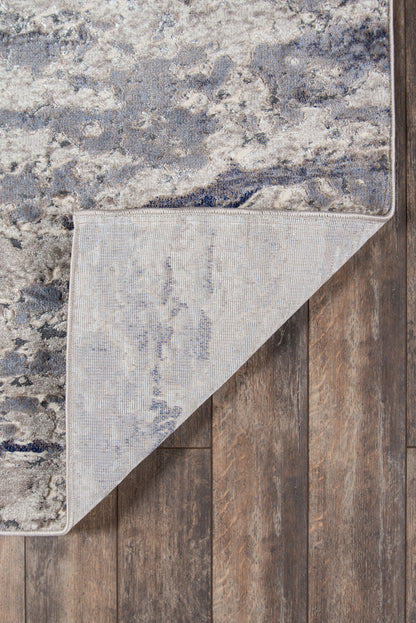 Rectangular blue-gray distressed area rug with ivory marbling, soft woven pile; reversible beige underside.