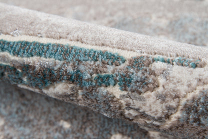 Beige and cream textured rug with teal abstract accents, thick plush pile and folded edge.