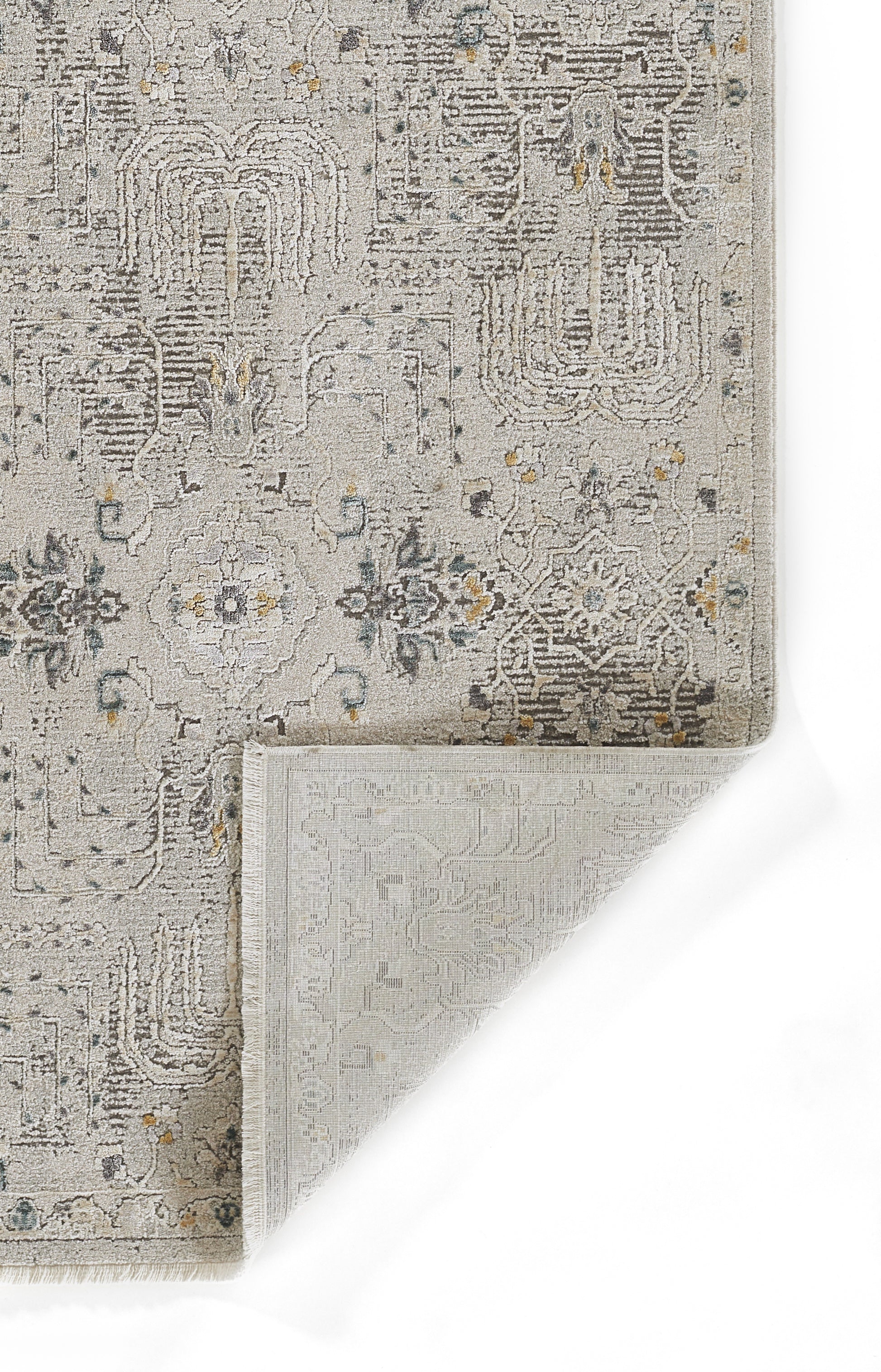 Gray vintage rug with a distressed floral/geometric pattern, subtle blue & yellow accents; corner folded to reveal reverse weaving.