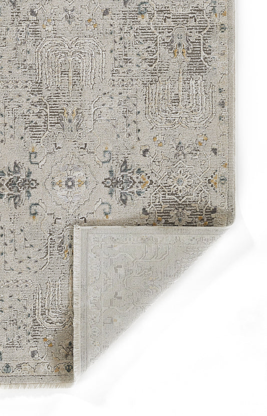 Gray vintage rug with a distressed floral/geometric pattern, subtle blue & yellow accents; corner folded to reveal reverse weaving.