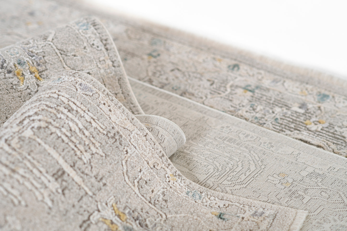 Grey-beige traditional patterned area rug with blue and pale yellow accents; plush pile and rolled edge.