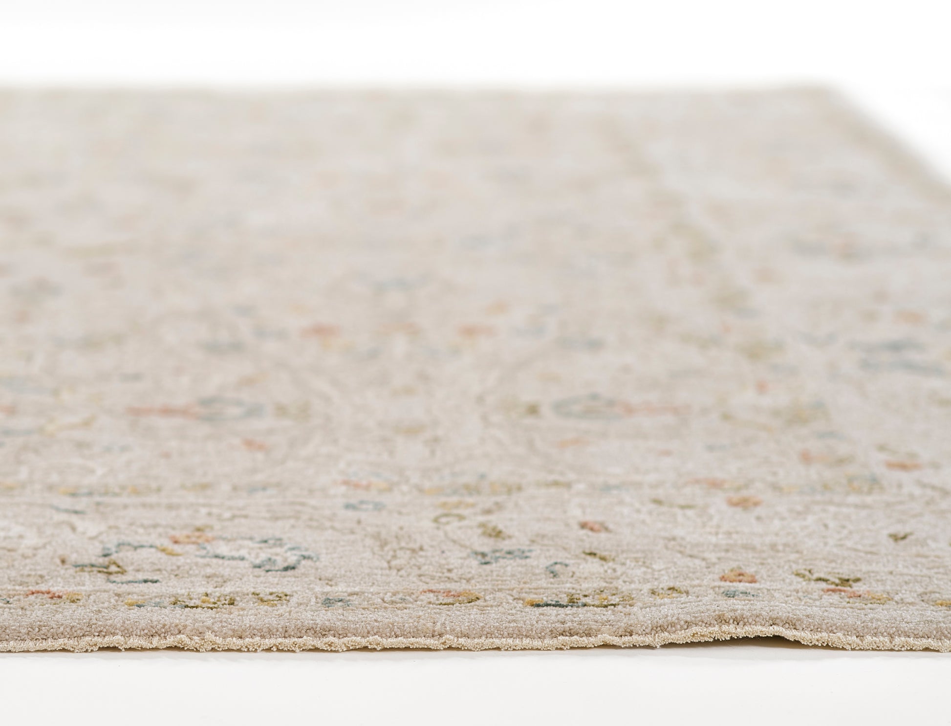 Beige woven area rug with delicate pastel floral motifs in blue, pink and green.