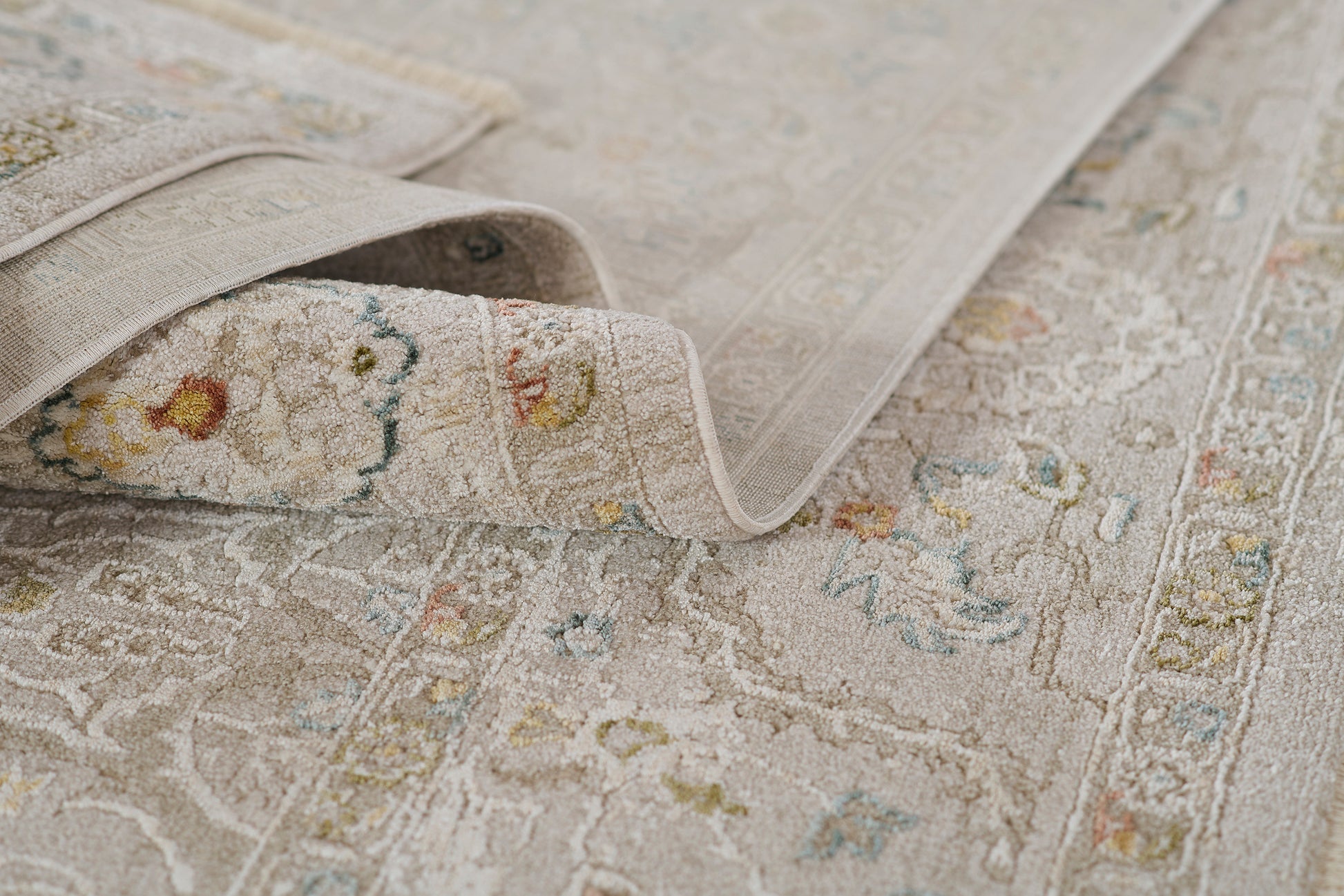Beige vintage-style rug with faded floral medallion pattern and soft pile for living room decor.