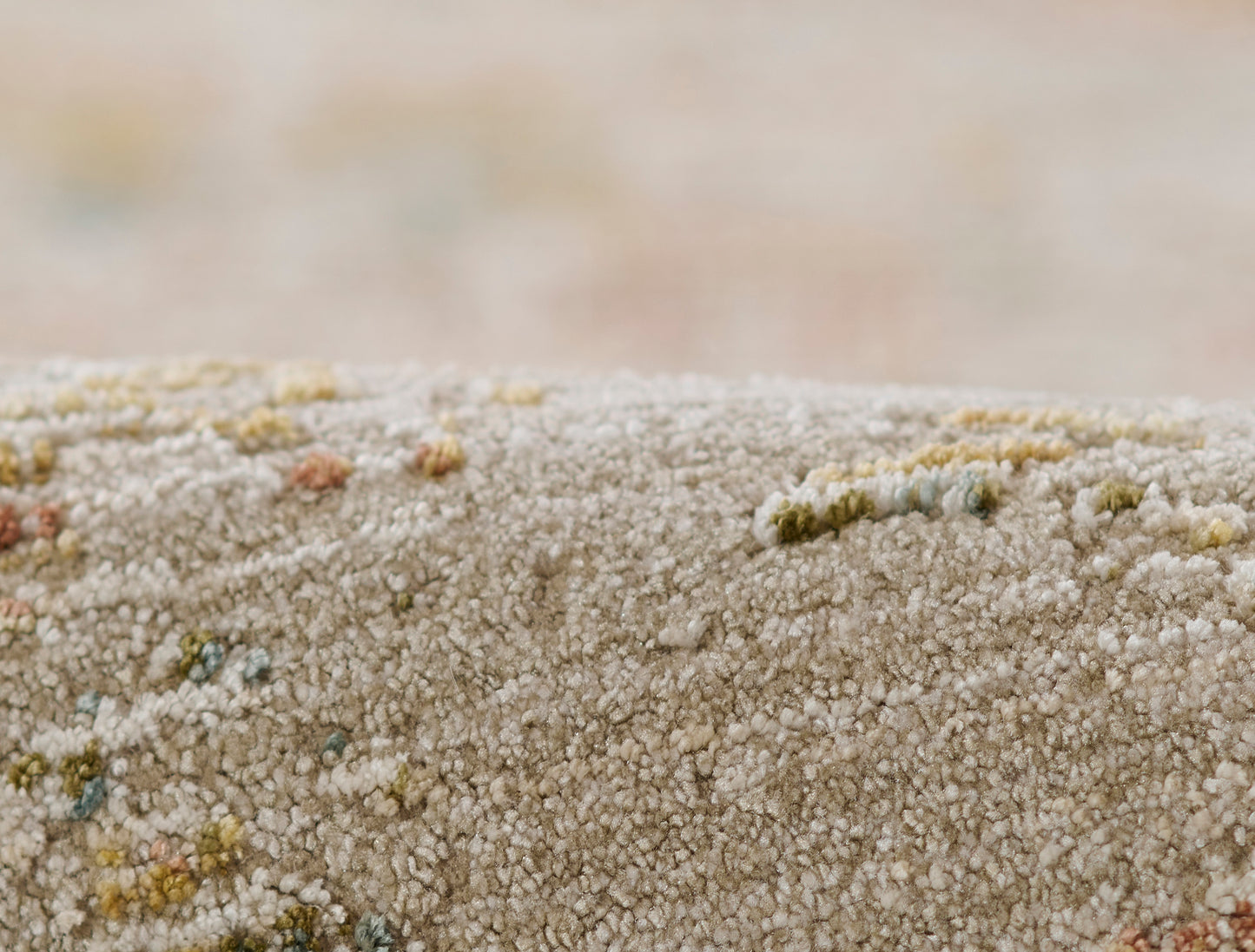 Beige shaggy rug with multicolor specks, plush tufted pile for cozy living room decor.