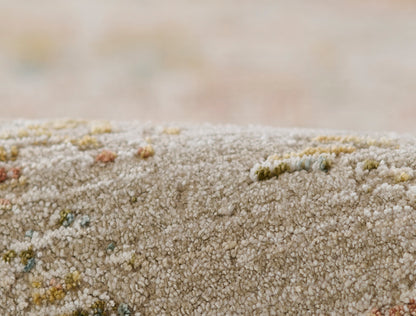 Beige shaggy rug with multicolor specks, plush tufted pile for cozy living room decor.