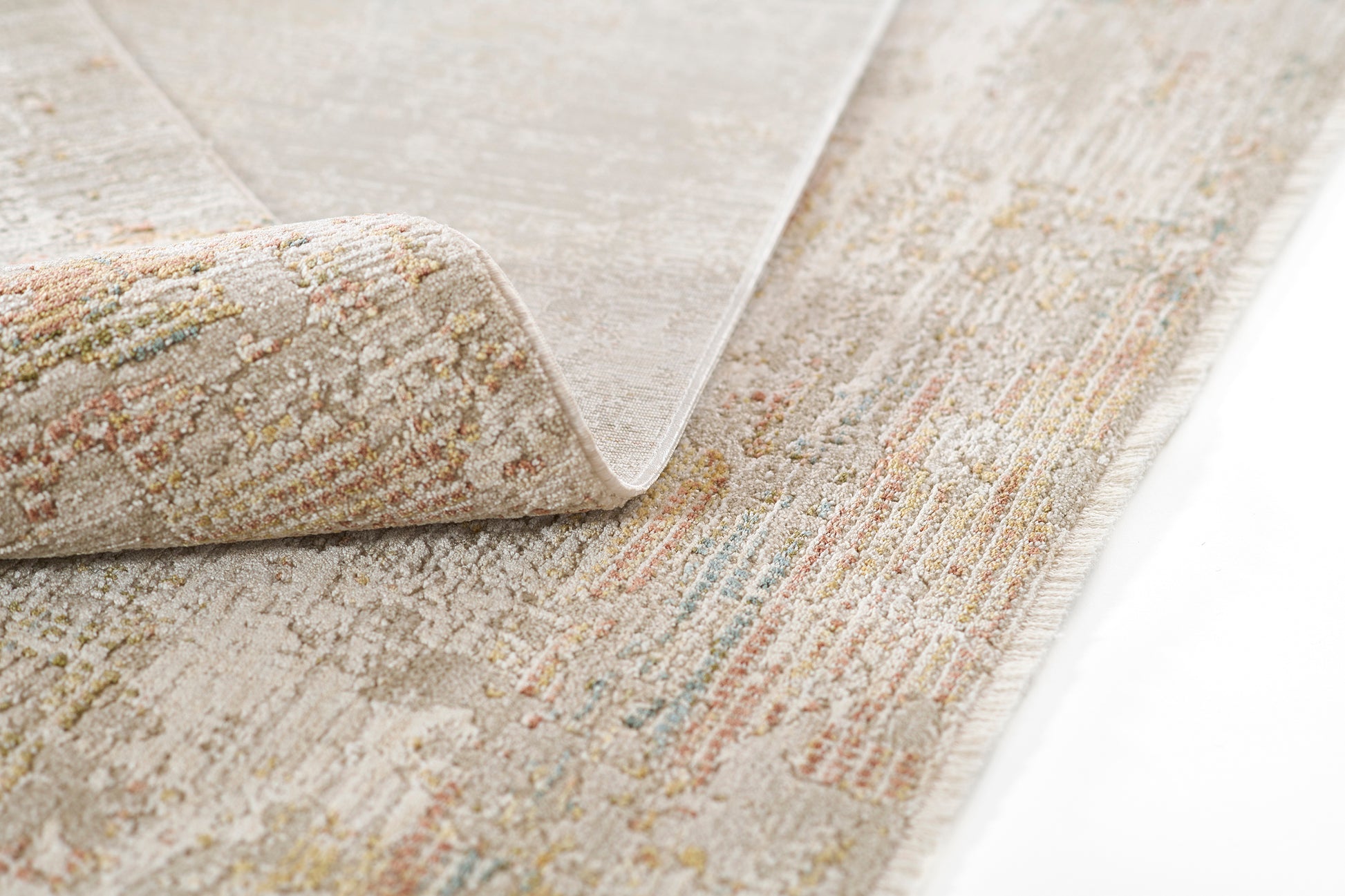 Beige area rug with soft pastel multicolor accents, textured pile, rolled corner showing underside.