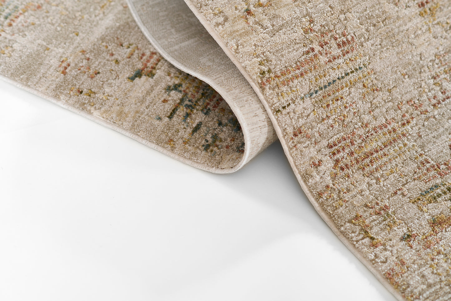 Beige textured area rug with muted multicolor streaks; rolled at the corner on a white surface.