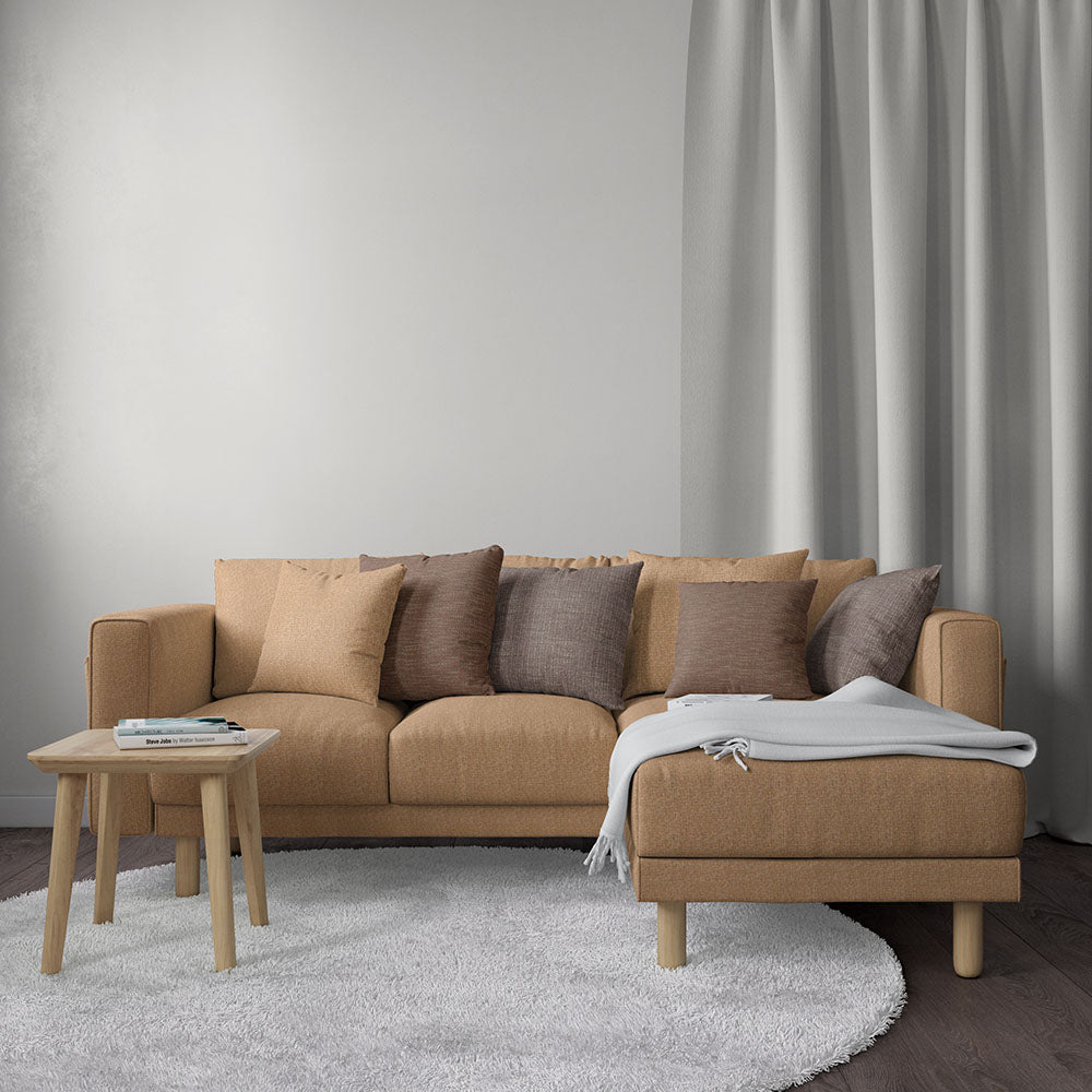 Beige solid fabric upholstery on an L-shaped sofa with taupe cushions and chaise, wooden legs, round wooden coffee table and soft rug.