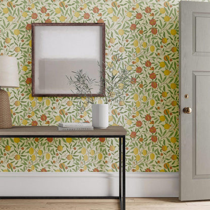 William Morris Fruit Wallpaper in Bayleaf/Russet by Morris & Co featuring ripened pomegranates, leafy branches, and detailed botanical motifs in rich green and warm russet tones. Classic Arts & Crafts wallpaper ideal for living rooms, dining rooms, bedrooms, studies, and elegant feature walls.