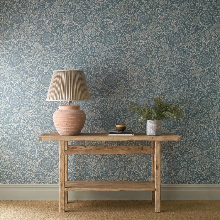 Morris & Co. Chamomile Wallpaper in China Blue showcasing a soft botanical pattern of delicate chamomile flowers, organic stems, and intricate hand-drawn details on a calming blue background. This elegant floral wallpaper from The Unfinished Works collection reflects William Morris-inspired Arts & Crafts design, creating a timeless and sophisticated wallcovering for bedrooms, living rooms, dining areas, home offices, and classic interior spaces.
