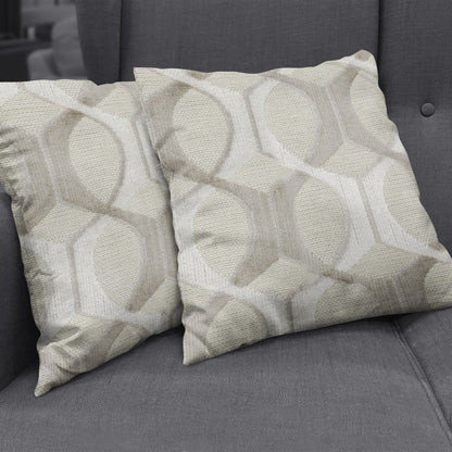Two beige textured throw pillows with a repeating circular geometric pattern on a dark grey sofa.