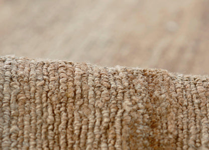 Beige-brown textured looped-pile rug with dense plush fibers.