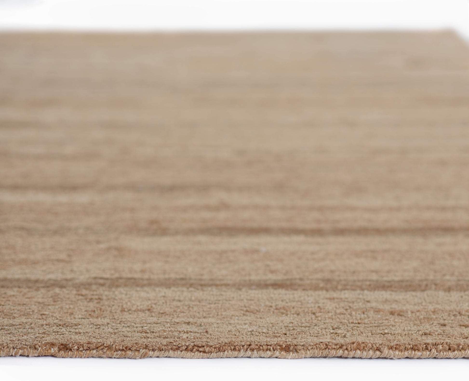 Natural beige jute rug with fringed edge, rectangular woven texture for living room or entryway.