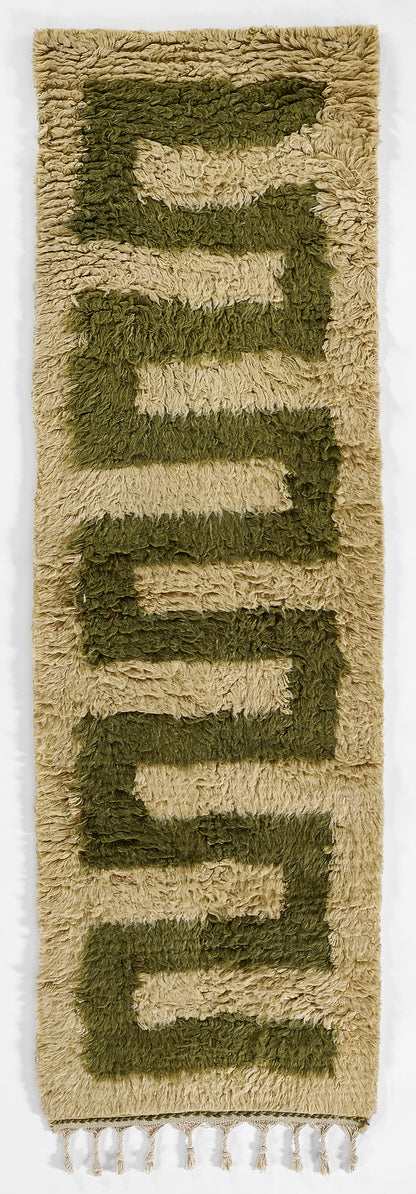 Beige shag rug with olive-green geometric blocks and tassel fringe, 2' x 3'.
