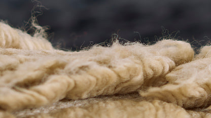 Close-up of thick natural beige jute rope, twisted fibers with fuzzy texture, rustic decor rope for crafts.