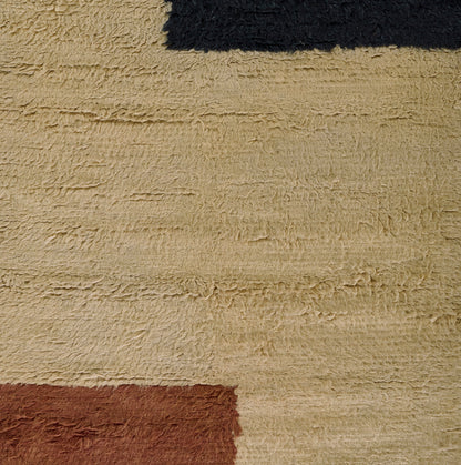 Beige high-pile shag rug with navy and rust color-block accents; soft, plush texture, modern bold pattern.