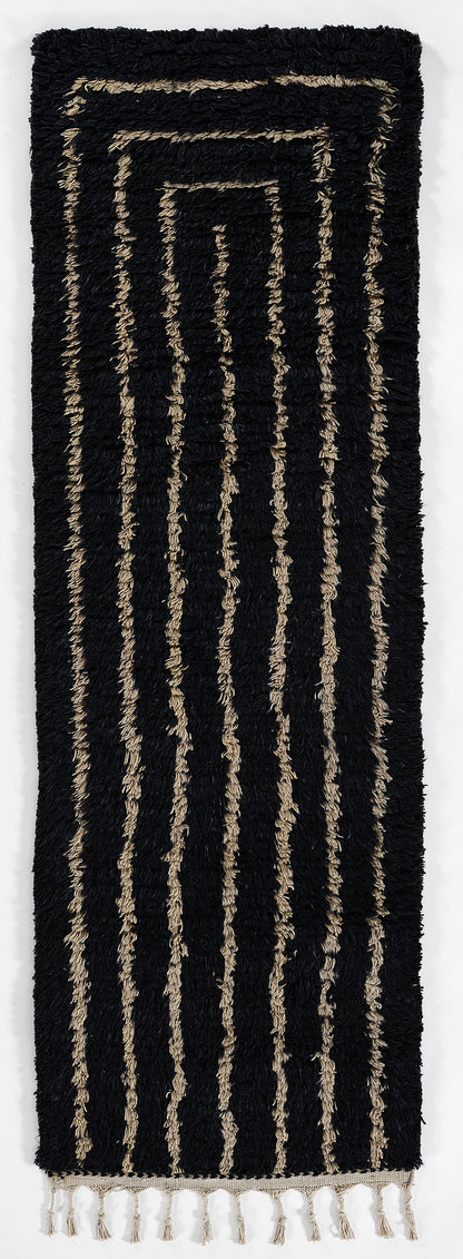 Navy shaggy rug with cream-beige concentric rectangle stripes and beige fringe at the bottom.