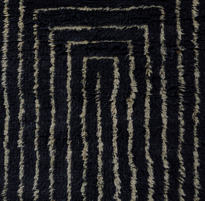 Navy and beige shag rug with raised geometric spiral rectangle pattern; soft tufted texture.