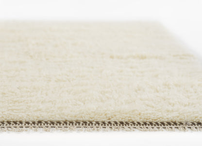 Cream shag rug with soft ivory pile and fringed edge; plush, high-pile texture.