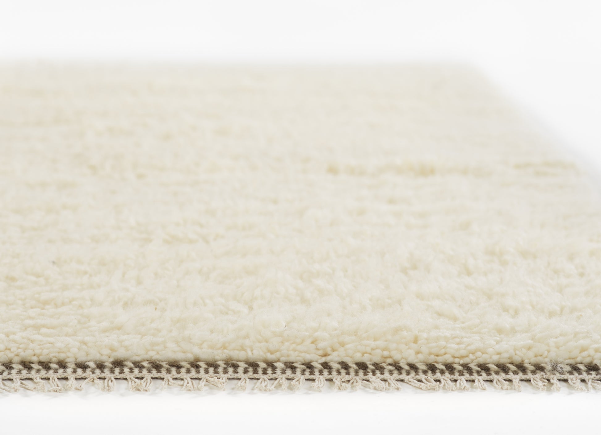 Ivory shag runner rug with plush cream pile and fringe trim along the edge; soft rectangular runner for living room.
