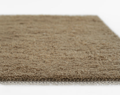Beige shag rug with plush loop pile and fringe edge, natural neutral floor covering for living spaces