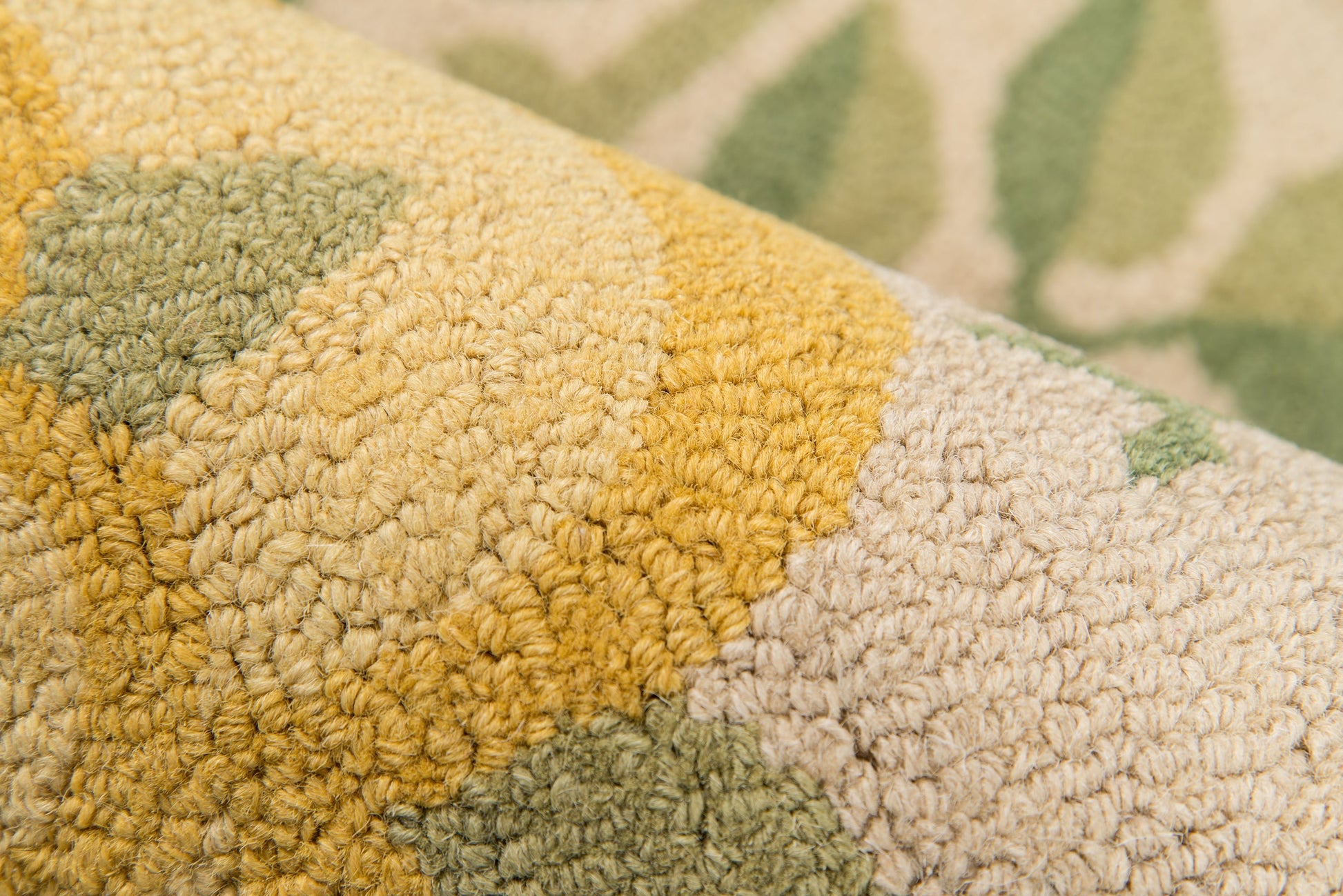 Close-up of a plush looped rug in mustard yellow, beige and olive green with a soft, textured pile.