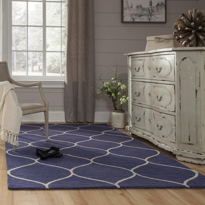 Blue rug with white lattice pattern on hardwood floor.