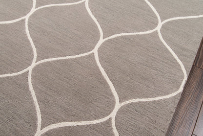 Gray textured rug with white curved lines forming irregular shapes, laid over wood flooring.